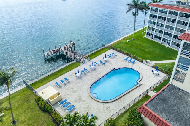 view of swimming pool featuring a patio, a lawn, and a water view