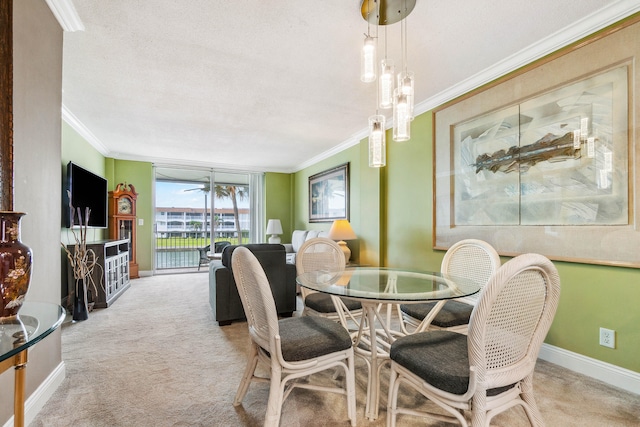 carpeted dining space with a textured ceiling, ceiling fan, and crown molding