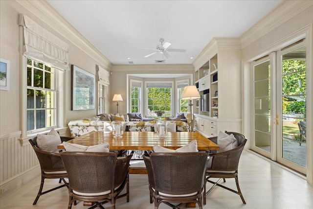 dining space with ceiling fan, light wood-type flooring, crown molding, and french doors