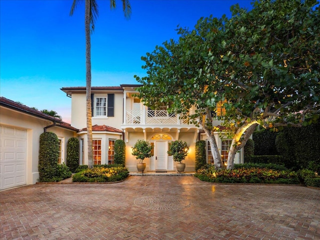 view of front of property featuring a garage and a balcony