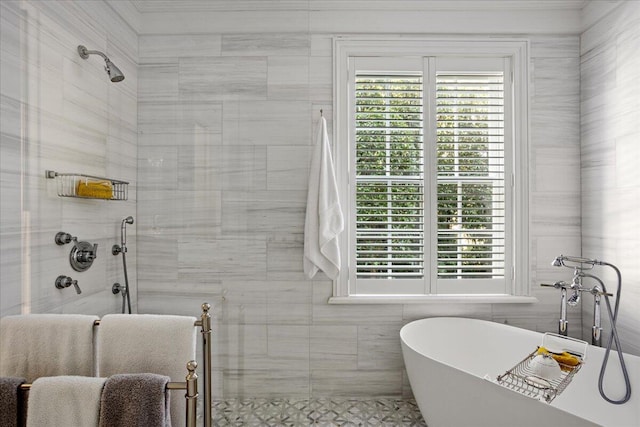 bathroom featuring shower with separate bathtub and tile walls