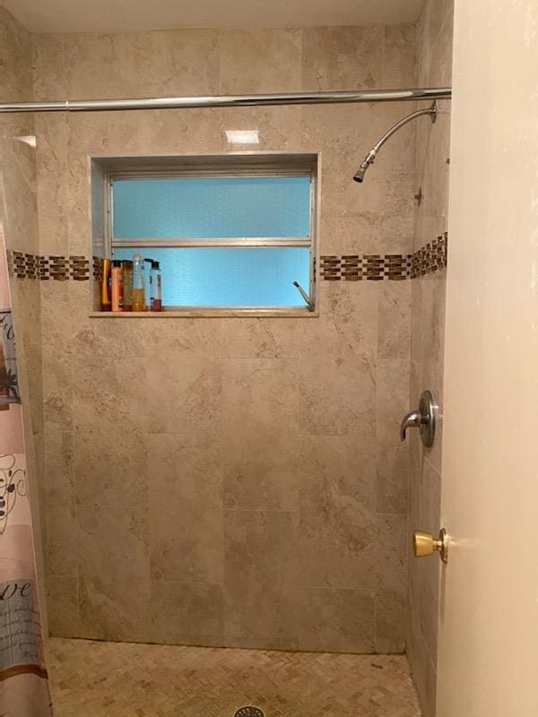 bathroom featuring a tile shower