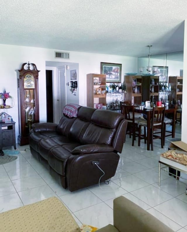 living room with a textured ceiling and light tile floors