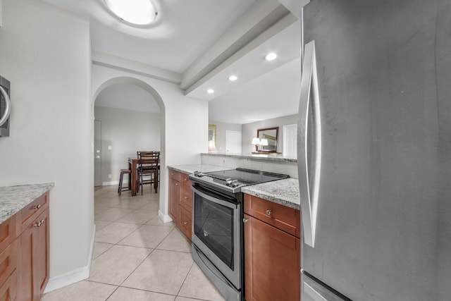 kitchen featuring light tile patterned floors, appliances with stainless steel finishes, and light stone countertops