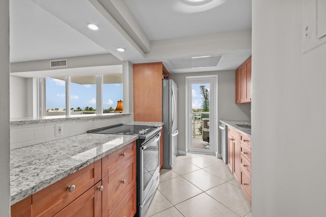 kitchen with decorative backsplash, light tile patterned flooring, stainless steel appliances, and light stone countertops