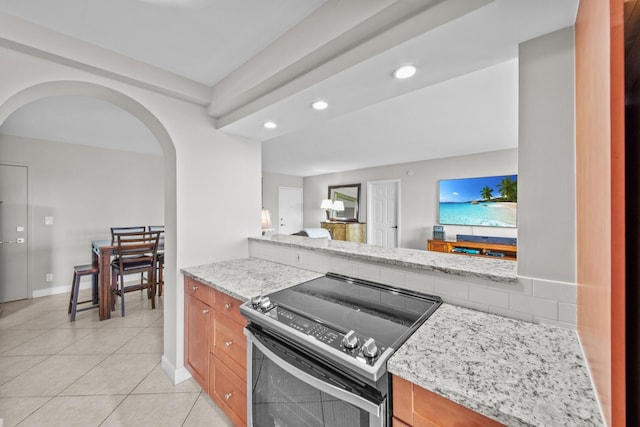 kitchen featuring electric range, light tile patterned floors, and light stone countertops