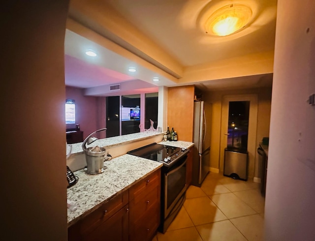 kitchen with light stone countertops, light tile patterned flooring, electric range oven, and stainless steel refrigerator