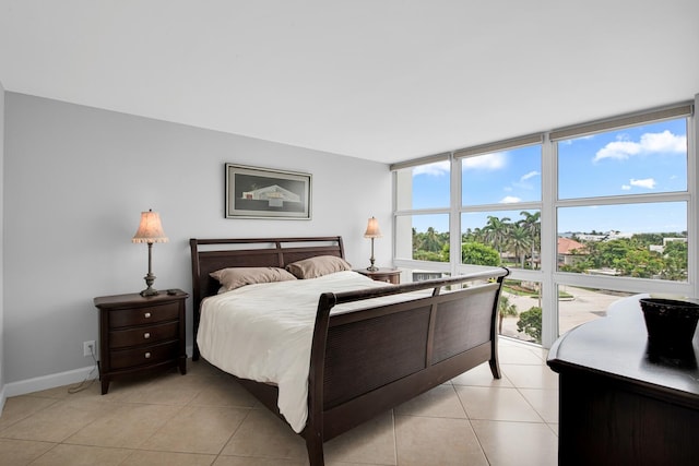 bedroom with light tile patterned floors and floor to ceiling windows