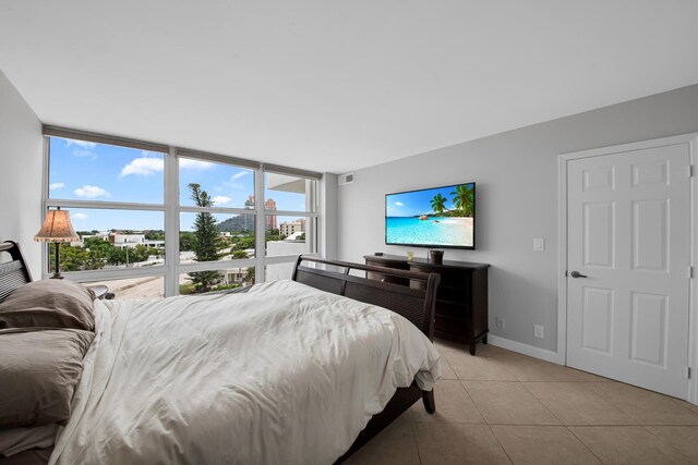 bedroom featuring light tile patterned floors and floor to ceiling windows