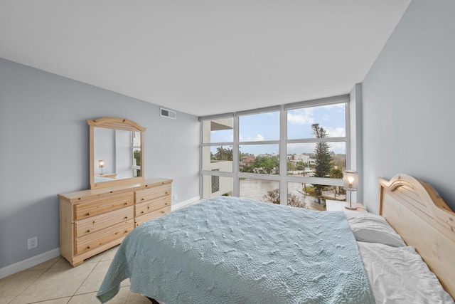 bedroom featuring light tile patterned flooring and expansive windows