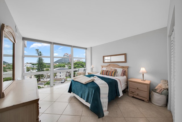 tiled bedroom with a wall of windows