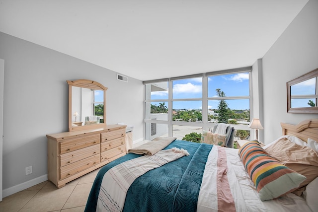 tiled bedroom with a wall of windows and multiple windows