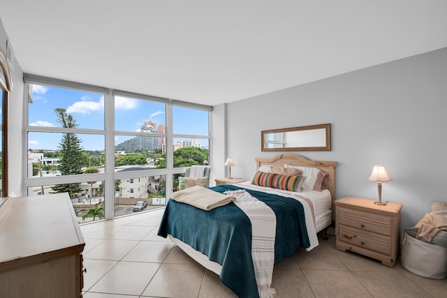 bedroom featuring floor to ceiling windows and light tile patterned floors