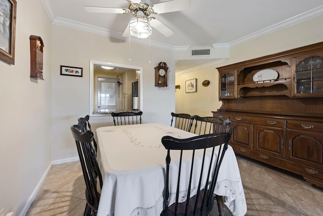 tiled dining area with ceiling fan and crown molding