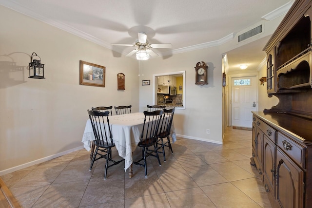 tiled dining space with crown molding and ceiling fan