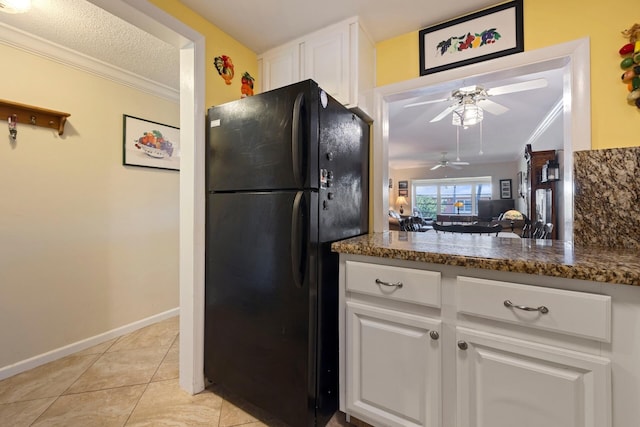 kitchen featuring ceiling fan, crown molding, black refrigerator, white cabinets, and light tile floors