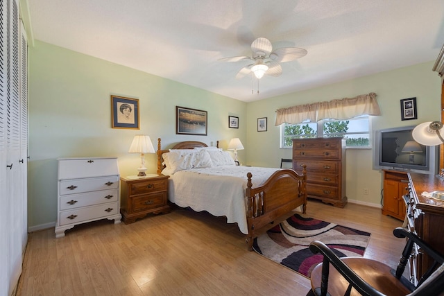 bedroom with ceiling fan, light hardwood / wood-style floors, and a closet