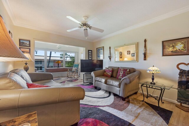 living room with hardwood / wood-style flooring, a healthy amount of sunlight, crown molding, and ceiling fan