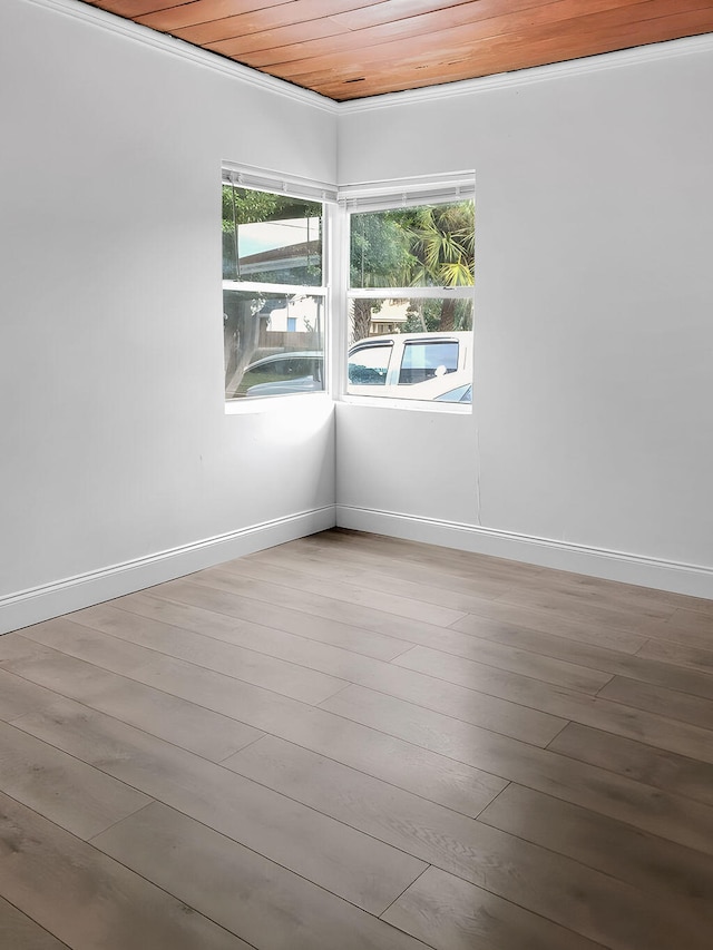 empty room with wooden ceiling, hardwood / wood-style floors, and ornamental molding