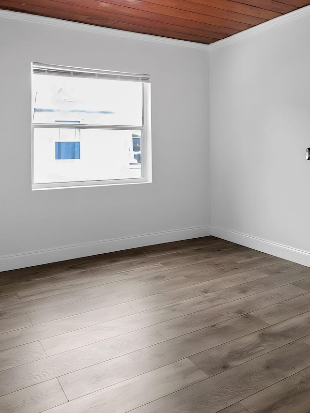 spare room featuring wood ceiling, ornamental molding, and wood-type flooring