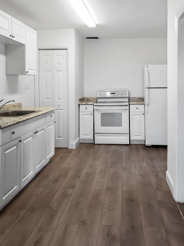 kitchen with white cabinets, white appliances, dark hardwood / wood-style flooring, and sink