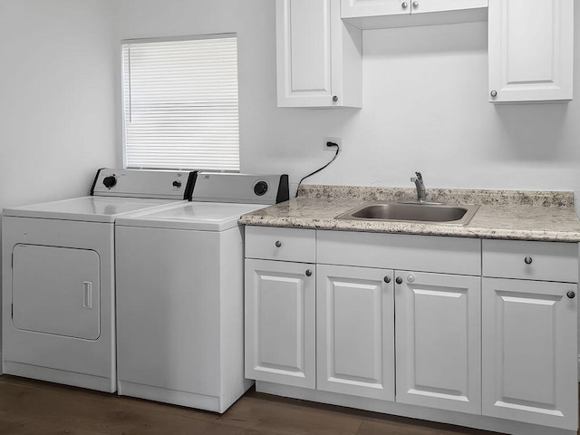 laundry area featuring sink, cabinets, dark hardwood / wood-style floors, and washing machine and clothes dryer