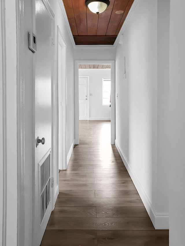 corridor featuring wooden ceiling, dark wood-type flooring, and crown molding