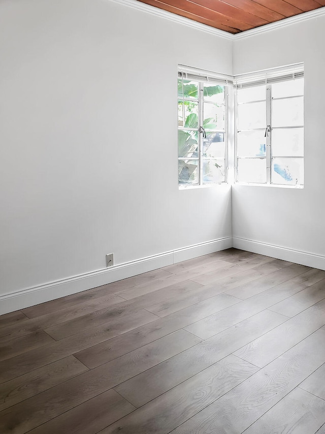 spare room with hardwood / wood-style floors, ornamental molding, and wood ceiling