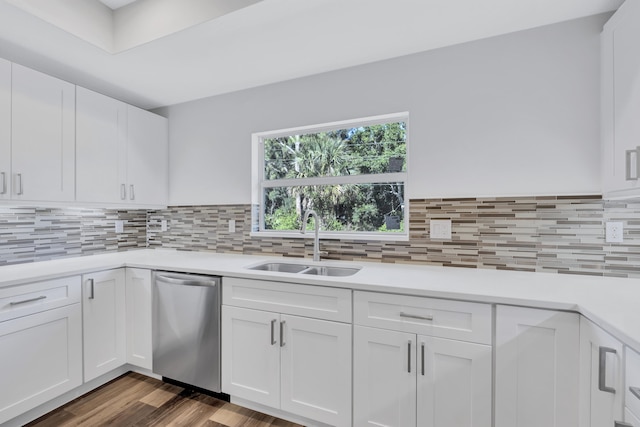 kitchen featuring white cabinets, dark hardwood / wood-style floors, backsplash, sink, and stainless steel dishwasher