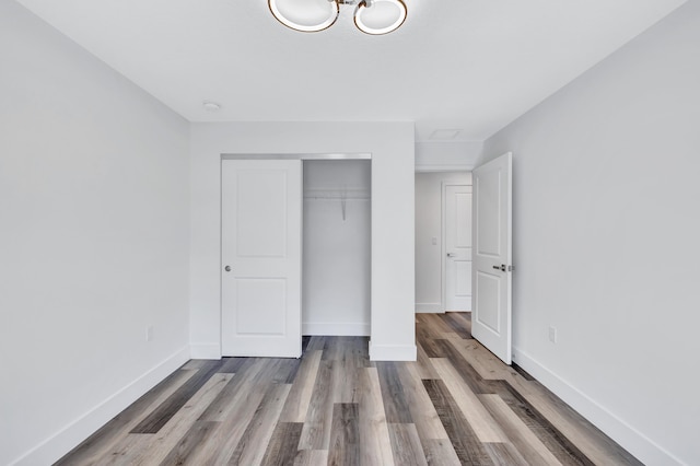 unfurnished bedroom featuring wood-type flooring and a closet