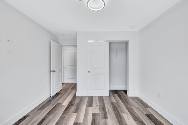 unfurnished bedroom featuring hardwood / wood-style floors and a closet