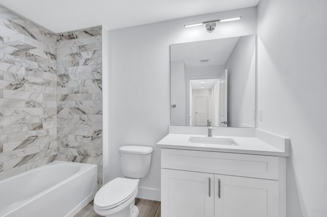 full bathroom featuring tiled shower / bath, wood-type flooring, toilet, and large vanity