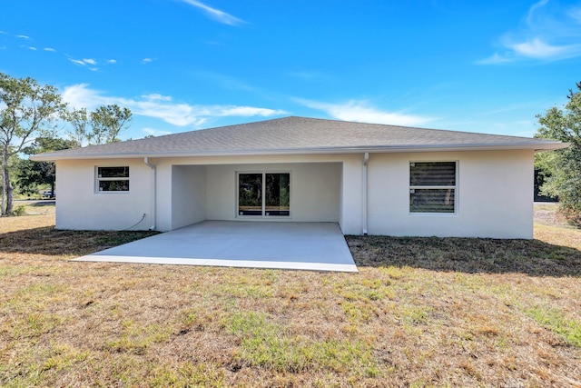 rear view of house with a yard and a patio