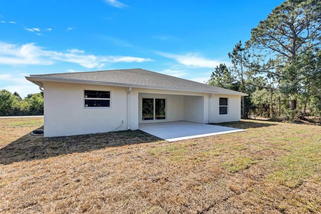 rear view of property with a patio and a lawn