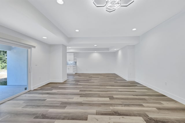 empty room featuring light hardwood / wood-style floors and a raised ceiling