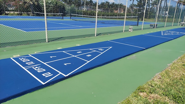 view of home's community featuring tennis court