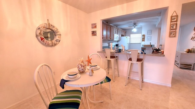 tiled dining space featuring ceiling fan