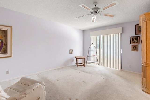 carpeted spare room featuring ceiling fan and a textured ceiling