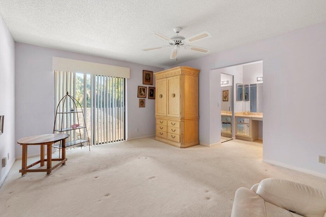 interior space featuring light carpet, ceiling fan, and a textured ceiling