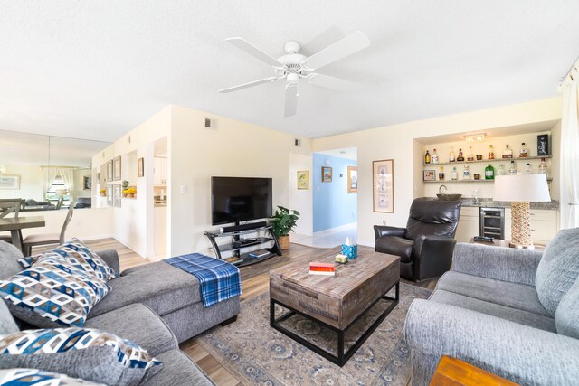 living room featuring ceiling fan, beverage cooler, and wood-type flooring