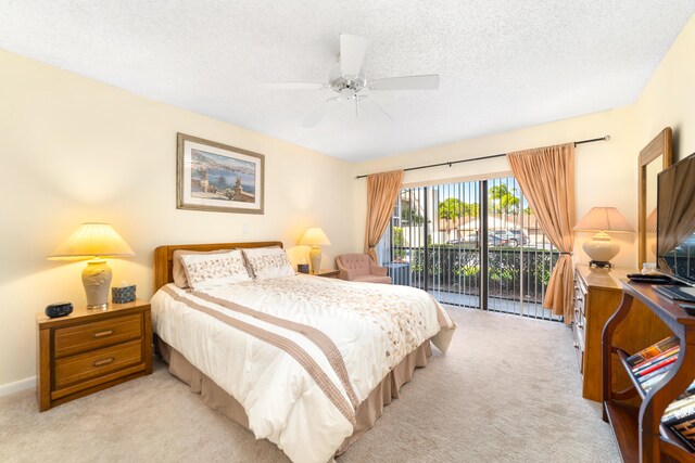 carpeted bedroom featuring access to outside, a textured ceiling, and ceiling fan