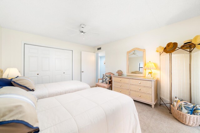 carpeted bedroom featuring ceiling fan and a closet