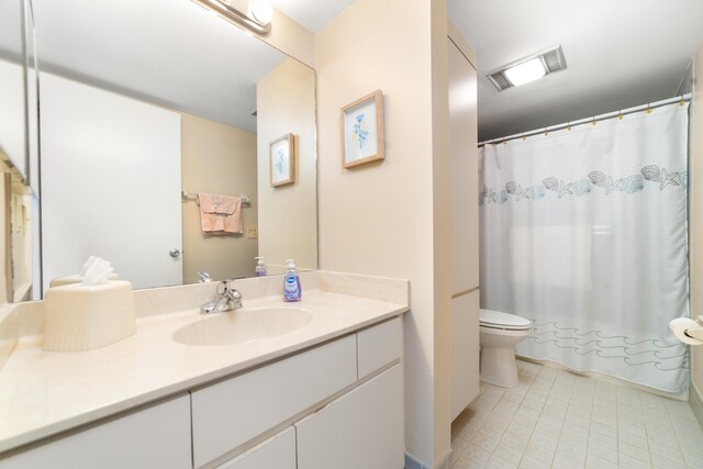 bathroom with tile flooring, toilet, and oversized vanity