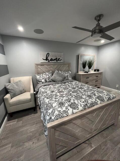 bedroom with dark hardwood / wood-style flooring and ceiling fan