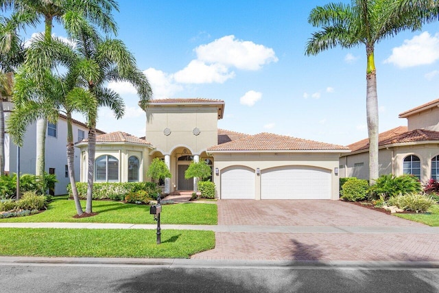 mediterranean / spanish house featuring a garage and a front yard