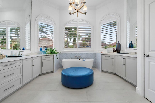 bathroom with tile patterned flooring, vanity, tile walls, a notable chandelier, and a washtub