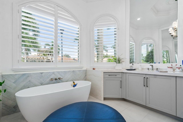 bathroom with vanity, tile patterned flooring, tile walls, a tub, and crown molding