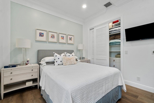 bedroom with dark wood-type flooring, a closet, and crown molding