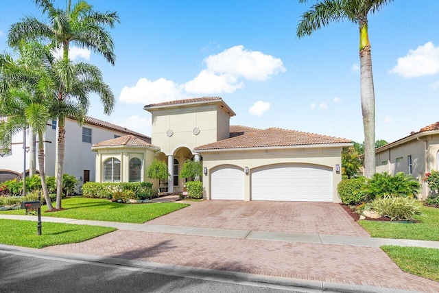 mediterranean / spanish-style house with a garage and a front lawn