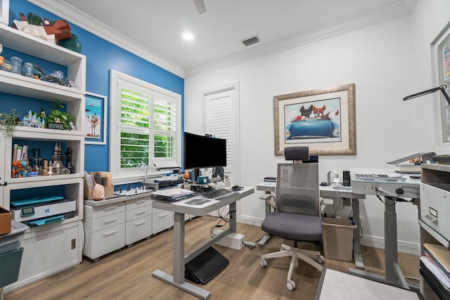 home office with light hardwood / wood-style flooring and ornamental molding